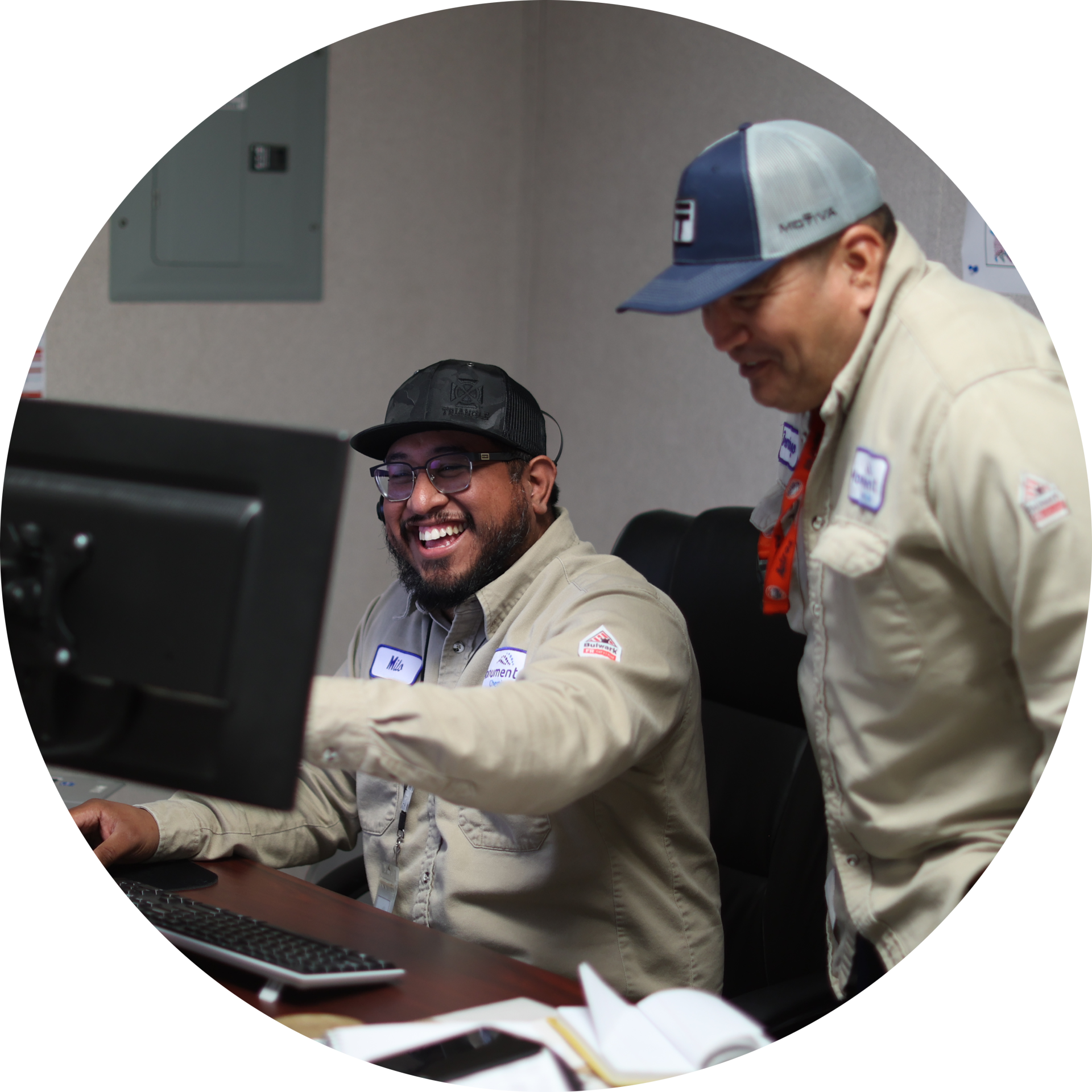 two Monument Chemical employees working on a computer